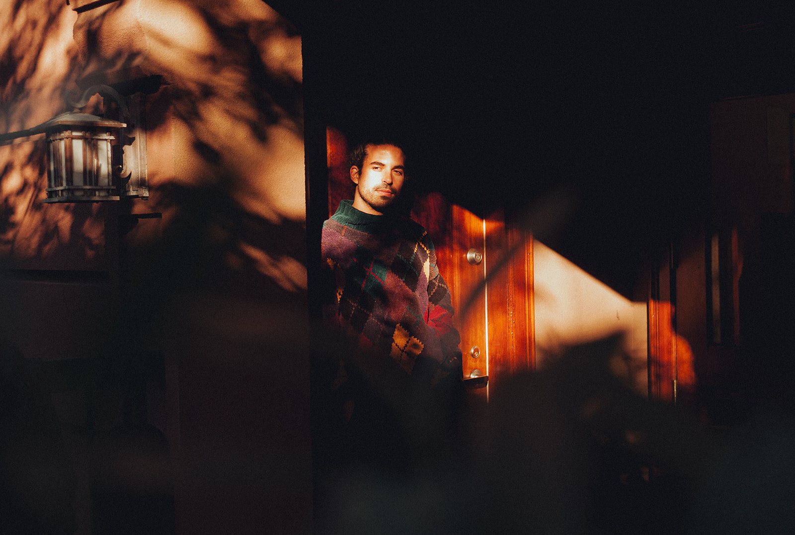 Kai Gluska in a lit doorway at dusk