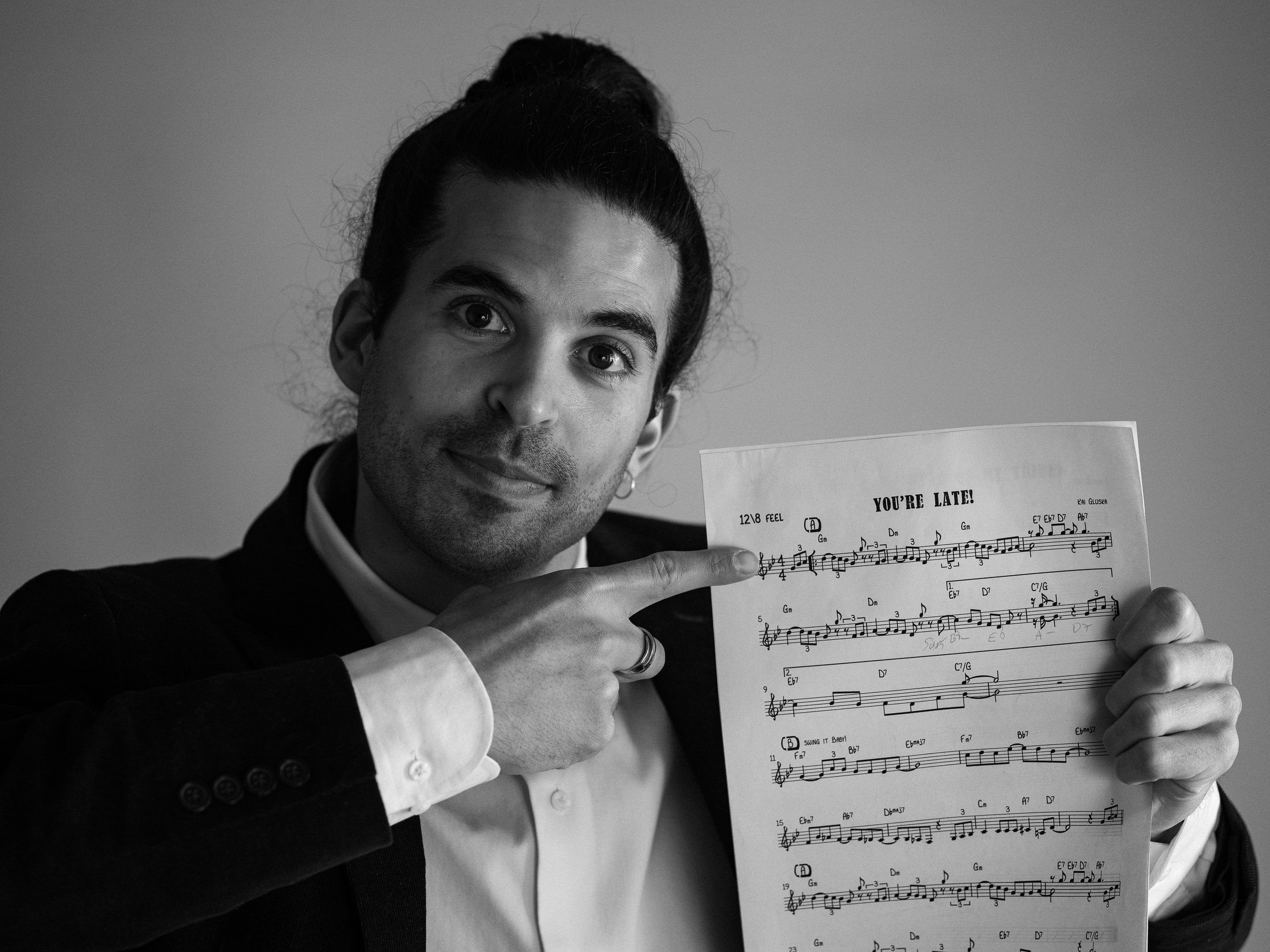 Kai Gluska holding a handwritten lead sheet for his composition "You're Late!"